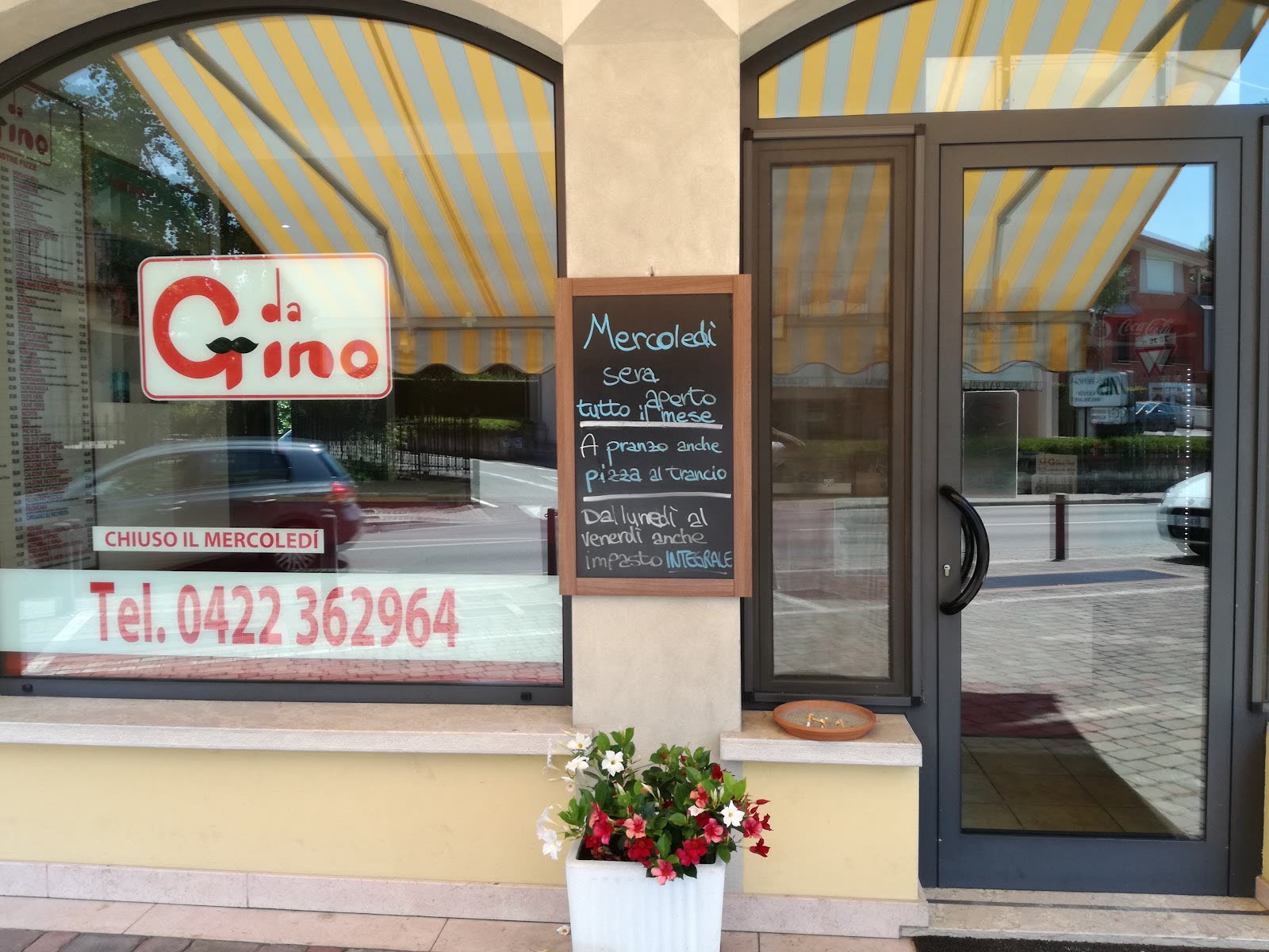 Il negozio in Via Lanzaghe, con l'insegna da Gino in vetrina e la tenda a righe gialle