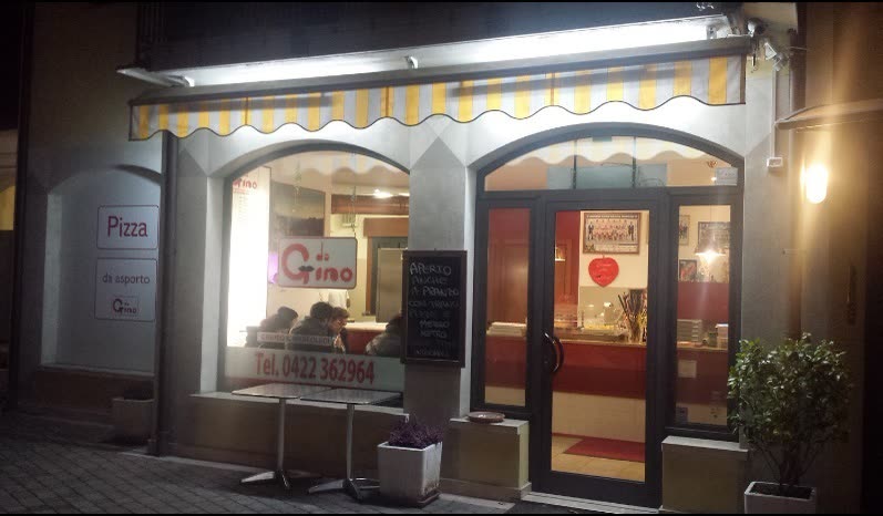 La pizzeria di sera, con l'insegna accesa